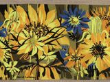 une photo d'un tapis orné de fleurs jaunes et bleues