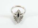 a close up of a silver ring with a black stone in the center