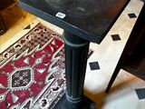 une petite table au plateau noir dans une pièce