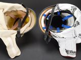 two hockey helmets sitting on top of each other on a black surface