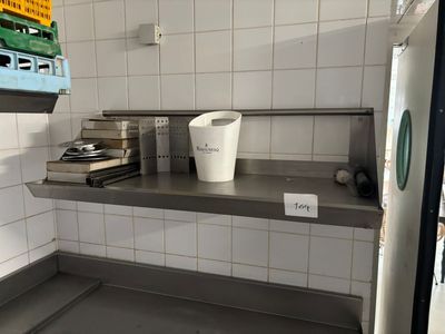 un seau blanc posé sur une étagère en métal dans une cuisine