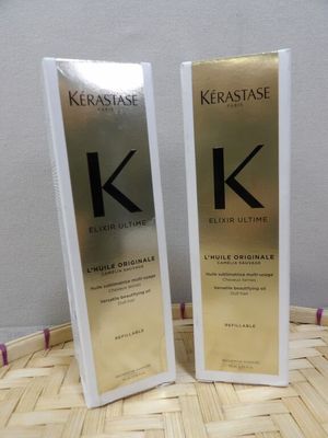 two bottles of kerastasee on a table with a basket in the background