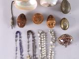 various shells and beads are arranged on a white surface