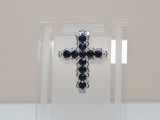 a cross made out of silver and black stones