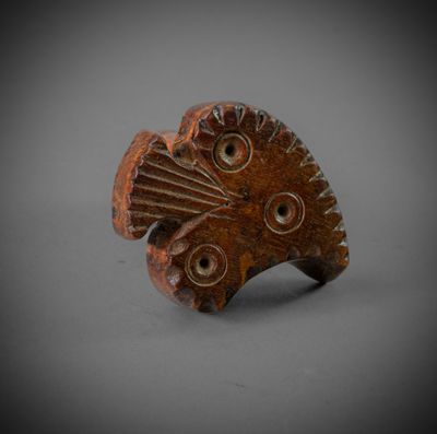 a close up of a wooden object on a gray surface