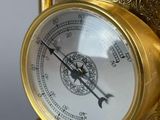 a gold clock that is sitting on a stand
