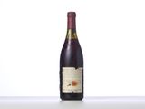 a bottle of wine sitting on top of a table next to a bottle of wine