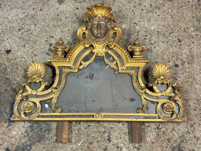 a gold mirror with a lion head on it