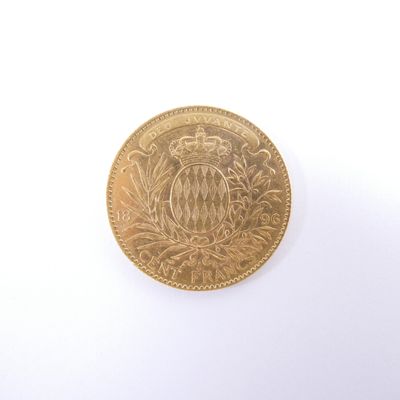 a gold coin with a crown on it on a white surface