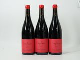 trois bouteilles de vin rouge posées côte à côte sur une table