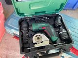 une boîte à outils verte posée par terre, contenant des outils