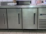 un plan de travail en acier inoxydable dans une cuisine équipée d'un réfrigérateur