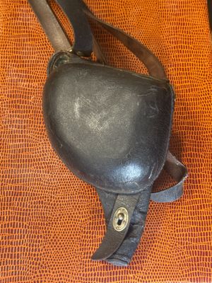 a black purse with a leather handle on an orange surface