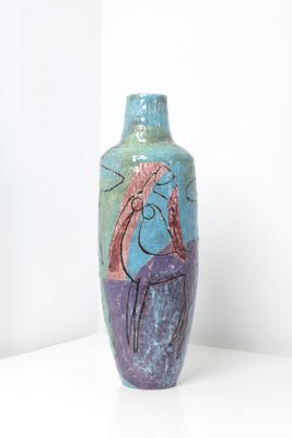 un vase avec un tableau posé sur une table