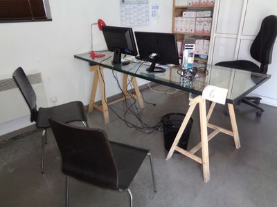 un bureau avec deux ordinateurs et une chaise devant