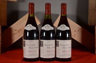 three bottles of wine sit on a red table cloth next to a wooden crate