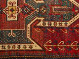 a close up of a red and blue oriental rug with geometric designs