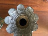 a metal flower shaped candle holder on a wooden table