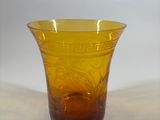 a yellow glass vase sitting on a white surface