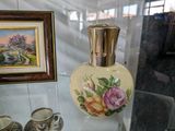 une vitrine en verre sur laquelle sont posés un vase et des tasses