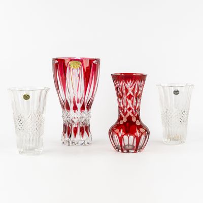 trois vases en verre rouge posés les uns à côté des autres sur une surface blanche