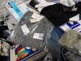 a pile of clothes and other items on a bed