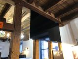 a television hanging from the ceiling in a room