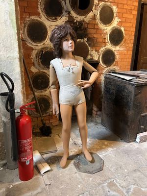un mannequin dans un coin de la pièce, à côté d'un extincteur