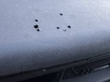 a close up of a car dashboard with bullet holes on it