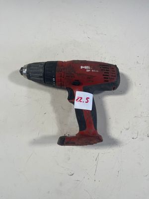une image représentant une perceuse sans fil posée sur une surface blanche