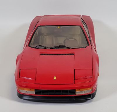 a red model of a sports car on a white surface