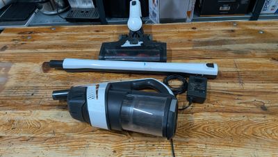 two vacuums sitting on a wooden table next to each other