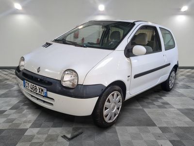 la photo d'une petite voiture blanche garée sur un sol en damier
