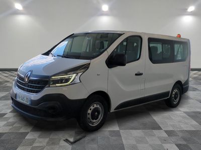 la camionnette blanche est garée sur le sol en damier d'un garage