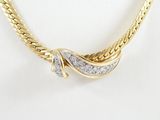 a close up of a gold necklace with diamonds on a mannequin