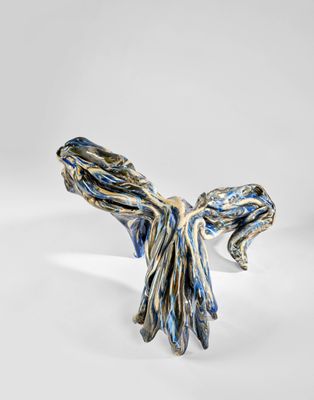 un gros plan d'une sculpture représentant un oiseau sur une surface blanche
