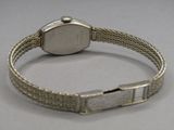 une photo d'une montre-bracelet avec un bracelet en métal posée sur une table