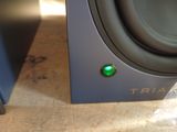 a close up of a speaker with a green button