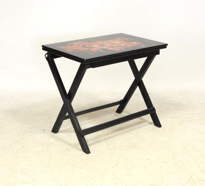 une image représentant une petite table noire ornée d'un motif rouge et noir