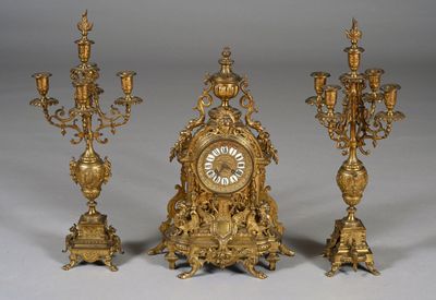 three gold colored clocks sitting next to each other on a table