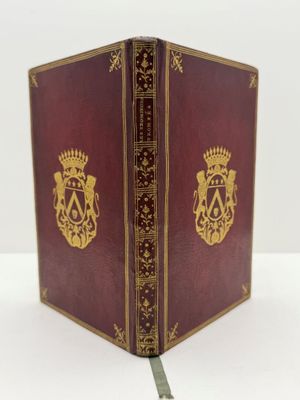 un vieux livre surmonté d'une couronne, posé sur une table