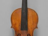 un gros plan d'un violon posé sur une surface grise