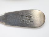 a silver spoon with a monogram on it