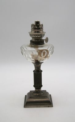 une lampe à huile à l'ancienne, surmontée d'un abat-jour en verre
