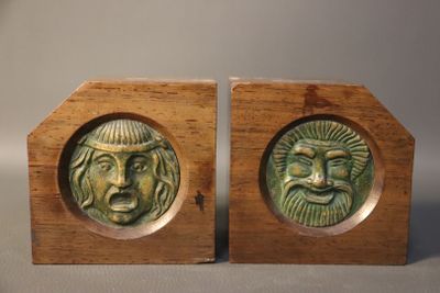 pair of wooden bookends with faces on them on a table