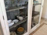 a glass cabinet with dishes and plates in it