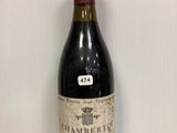 une bouteille de vin posée sur une table, à côté d'un verre de vin