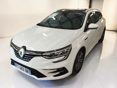 La voiture blanche est garée dans le showroom d'un concessionnaire.