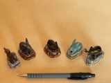 five figurines of animals and a pen on a table