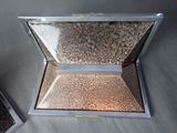 a small metal box with gravel inside of it
